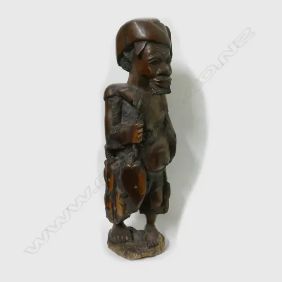 An African heavy carved ebony hardwood sculpture of a fisherman
