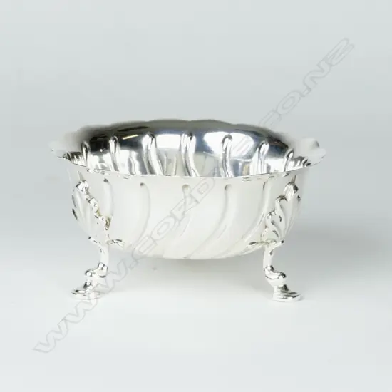 A small silver circular dish on tripod base