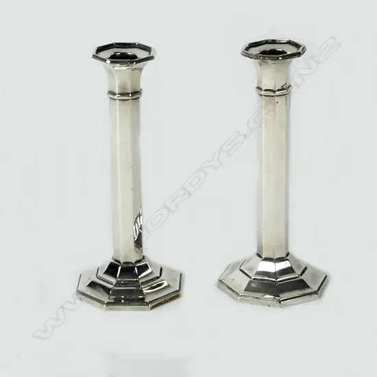 A pair of George V silver octagonal section column candlesticks