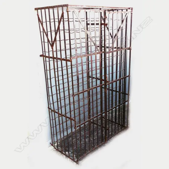 A large old iron wine rack of traditional cage design