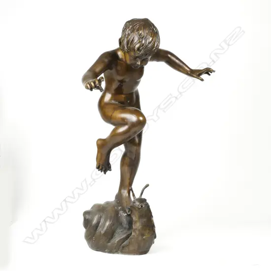A bronze figure of a young naked dancing boy
