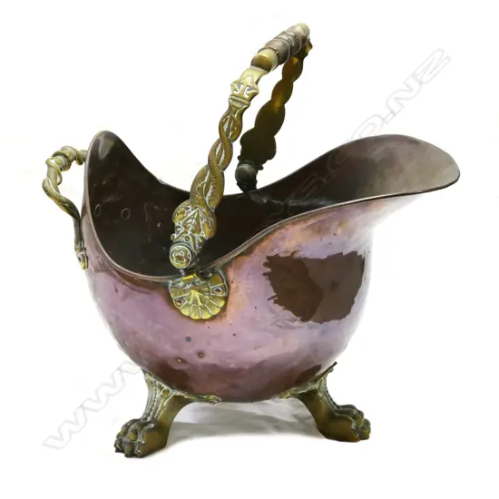 An ornate copper coal scuttle