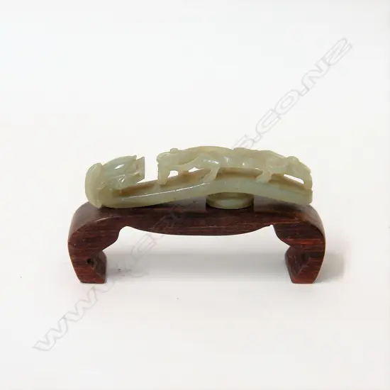 A Chinese carved pale green jade belt hook