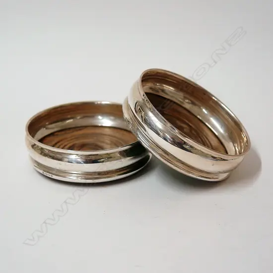 A pair of silver and turned wood bottle coasters