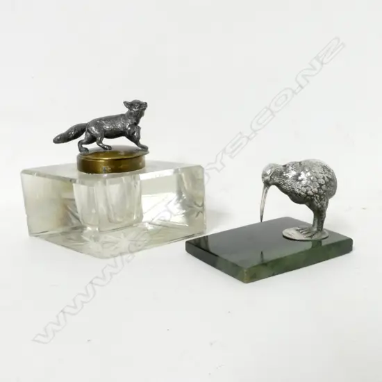 An antique paperweight with silver plated kiwi standing on a greenstone slab