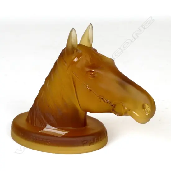 An amber depression glass paperweight