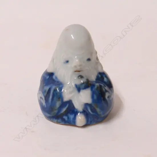 A small porcelain seated Hotei type netsuke