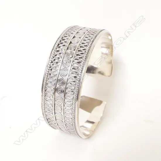 An ornate silver cuff