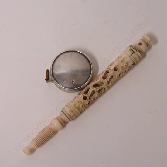 An Edwardian silver cased tape measure and carved bone needle case
