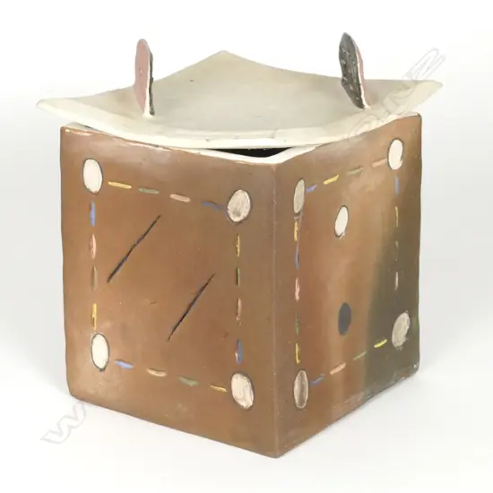 Denis O’Connor lidded cube with abstract patterns and a curved lid with 'dorsal fins'. Brown stain and incised dashes and circles in bright colours. The lid has an unglazed white body with two fins in brown and pink and pierced linear designs. Stamped monogram. The lid has a firing crack and one fin has been broken off professionally restored. Ref: Illustrated: 'Cone Ten Down'