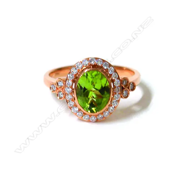 A lady's modern 18ct. rose gold peridot and diamond cluster ring