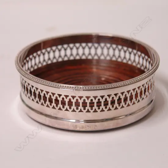 A modern silver galleried wine coaster