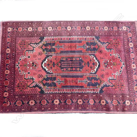 A hand knotted Baluchi tribal rug with stylised floral designs