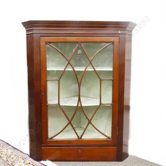 A Georgian mahogany hanging corner cabinet with a single glazed door