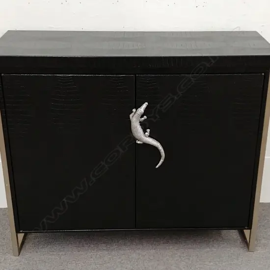 A stylish modern black 'crocodile skin' two door cabinet raised on two angular metal frames (one at each end) and a silvered metal crocodile handle