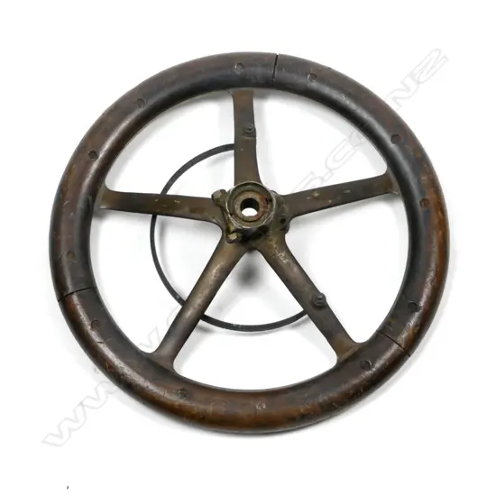 A vintage mahogany and bronze five-spoke car steering wheel