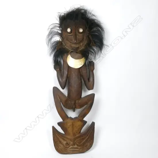 A large old Papua New Guinea carved figural food hook with lyre bird feather headrest