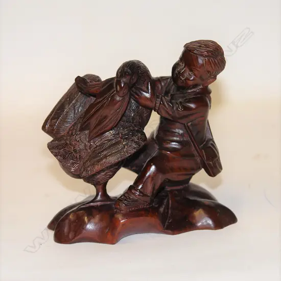 A Chinese carved hardwood Communist Maoist era figure of a young boy with a large bird