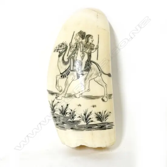 A 20thC scrimshaw whale's tooth depicting an amorous Indian couple riding upon a camel