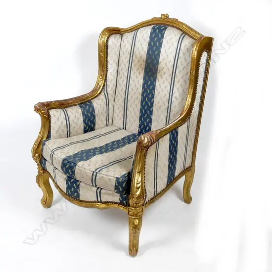 A pair of large gilt wing back armchairs of French style with leaf