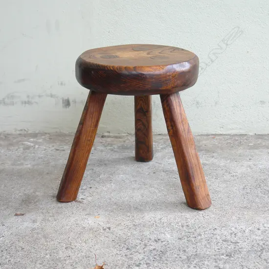 An antique country style elm milking stool