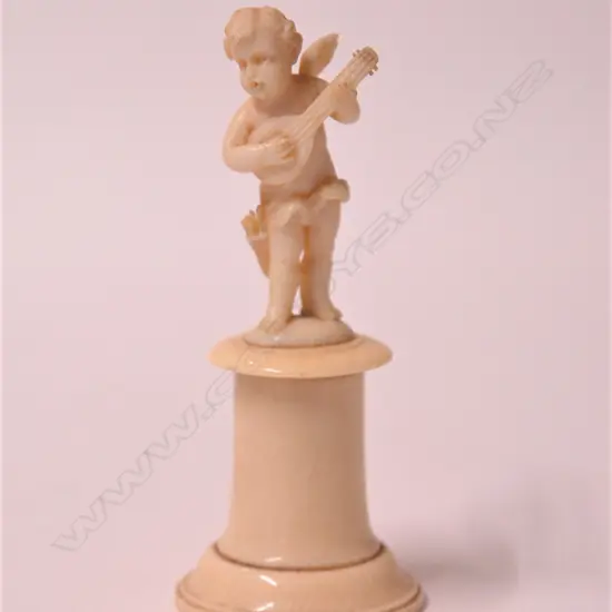 A small 19thC ivory carving of a cherub musician