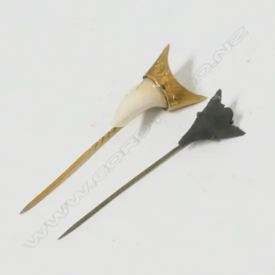 A gold mounted shark tooth set on a stick pin