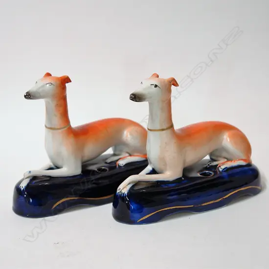 A pair of Staffordshire inkwells as recumbent greyhounds