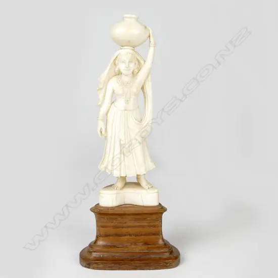 An Indian ivory carving of a woman carrying a water pot on her head