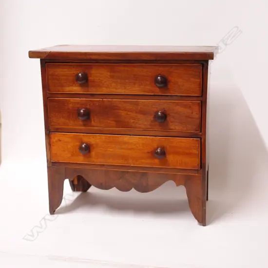 A Georgian walnut and mahogany miniature chest of drawers