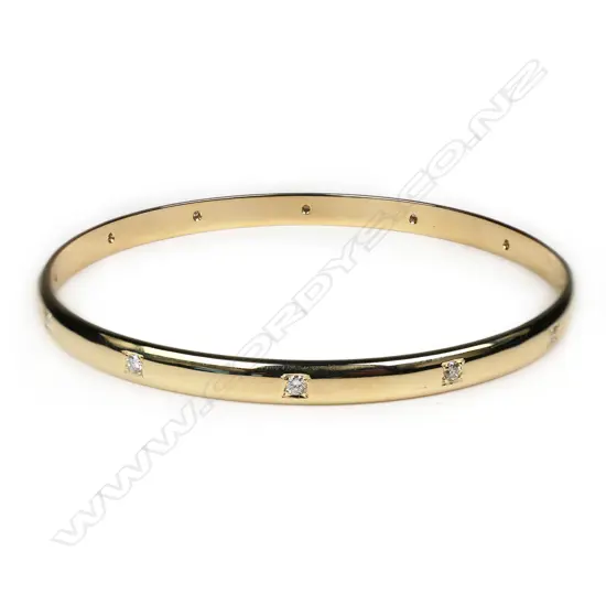 A modern 9ct yellow gold and diamond set bangle,
