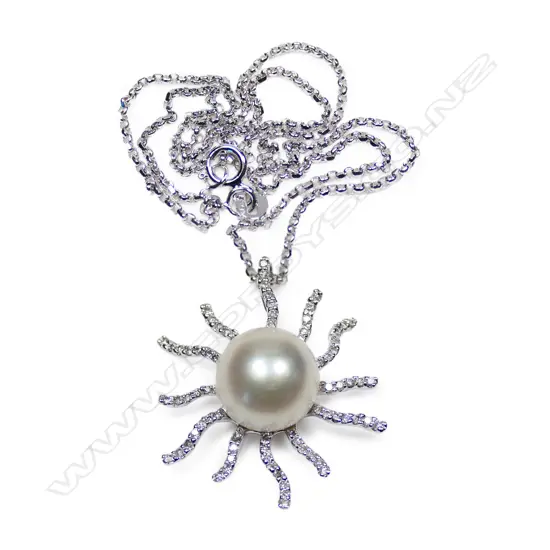 An 18ct white gold diamond and pearl set sun burst pendant necklace,