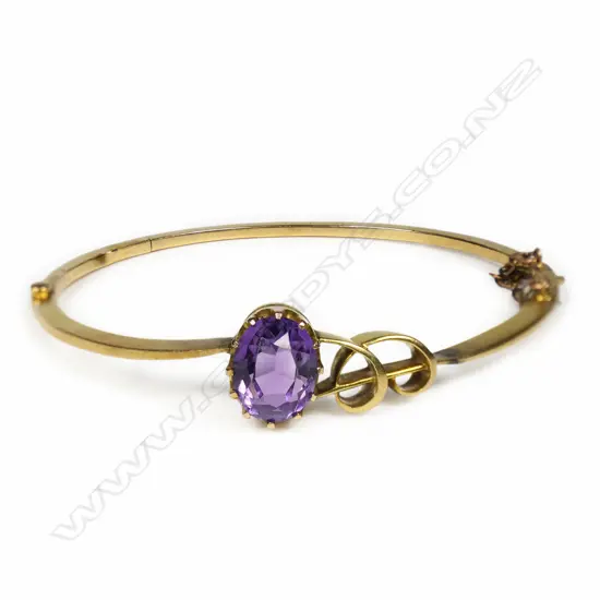 A c.1900 15ct yellow gold and amethyst hinged bangle,