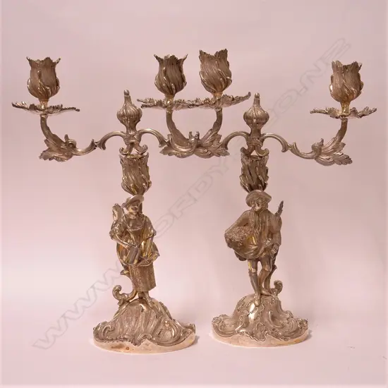 A pair of 20thC cast silver antique French style figured twin branch table candelabra
