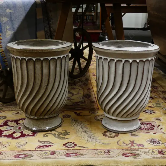 A pair of white glazed pottery garden urns