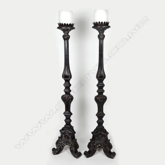 A pair of impressive tall floor standing gothic style wooden candlesticks