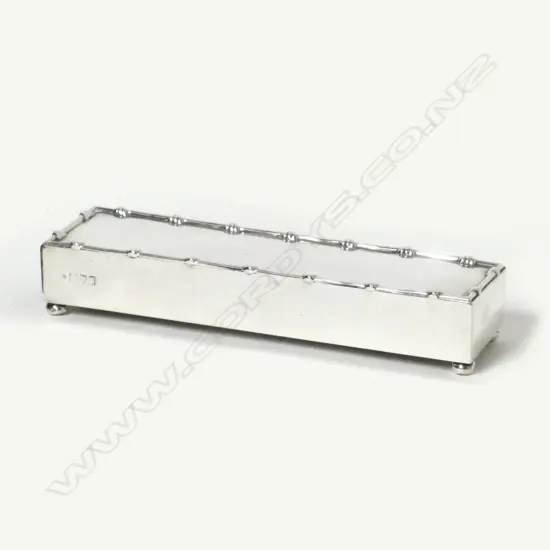 A silver match box frame