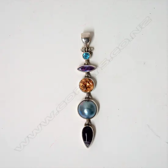 A modern decorative multi-stone and silver long drop pendant