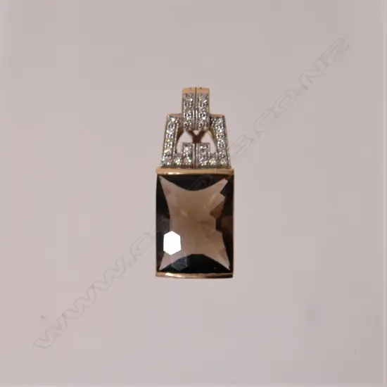 A 9ct. gold mounted stylish topaz and diamond pendant