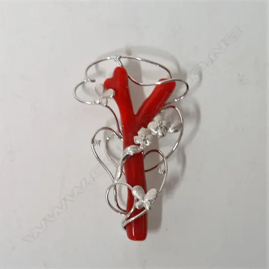 A modern 18ct. white gold red coral and diamond art form brooch