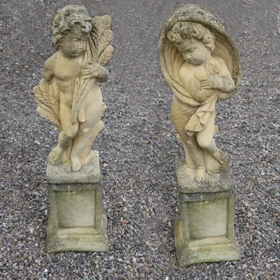 A pair of Church Stone garden statues on plinths