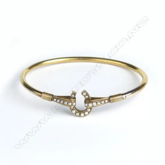 An Edwardian gold horseshoe mounted and seed pearl bangle