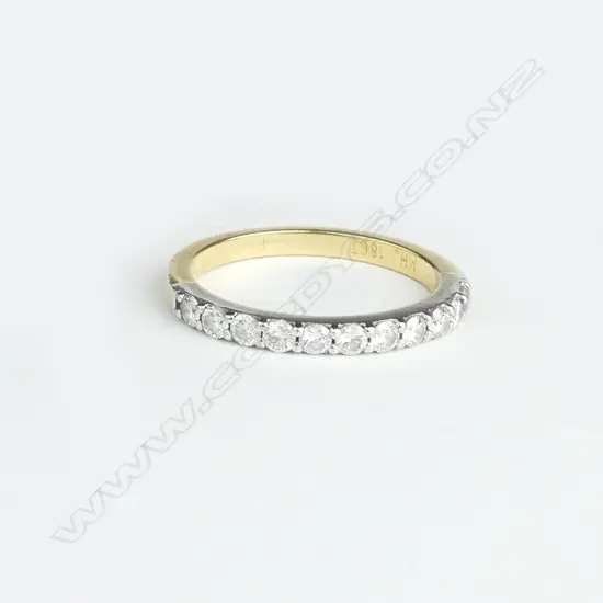 A lady's estate 18ct. yellow gold and eleven diamond band ring