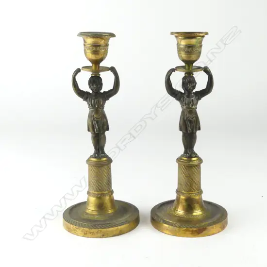 A pair of parcel gilt bronze candlesticks