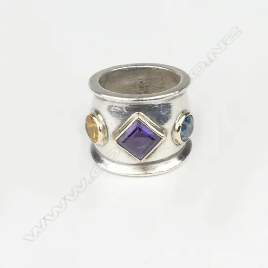 An 80's designer silver gold amethyst and peridot ring