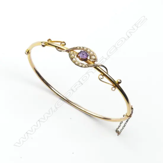 A 9ct. rose gold amethyst and seed pearl hinged bangle