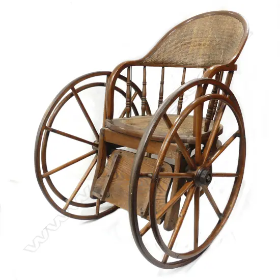 An Edwardian oak and cane wheelchair