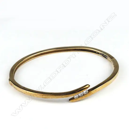 A vintage 9ct gold and diamond set hinged bangle
