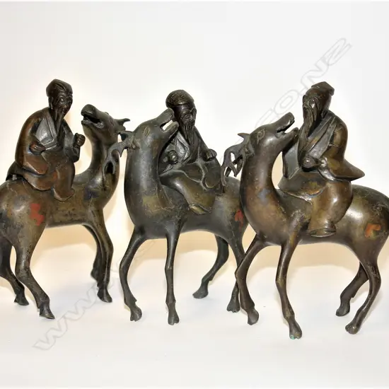 A set of three old Chinese bronze immortal figures on deer