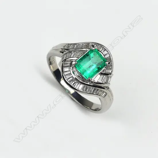 An emerald and diamond platinum set ring
